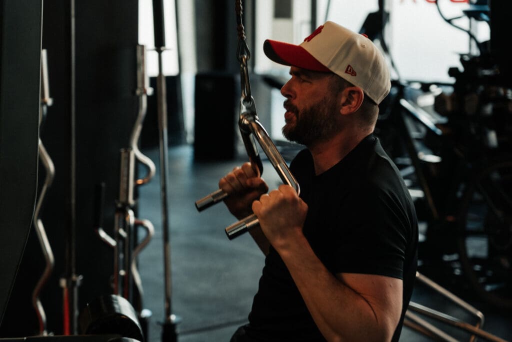 Man pulling cable handles toward his chest during a workout