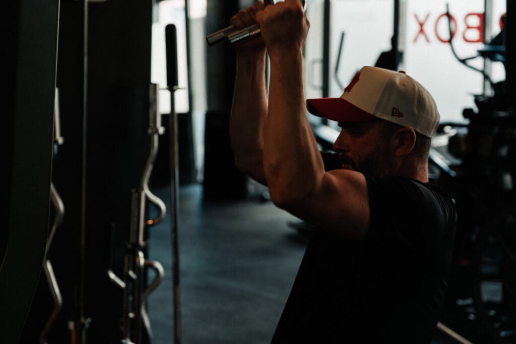 Man using an overhead cable machine in a gym